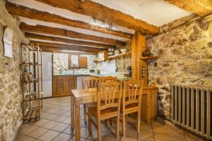 une cuisine et une salle à manger avec une table et des chaises en bois dans l'établissement Mas Vilardaga, à La Baronia de Rialb