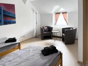 a bedroom with two beds and a chair and a table at Ferienwohnung Seeglück - 4 Schlaf- & 4 Badezimmer in Tauche