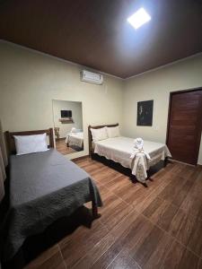 1 Schlafzimmer mit 2 Betten und Holzboden in der Unterkunft Chalés Pouso da Coruja in Cavalcante