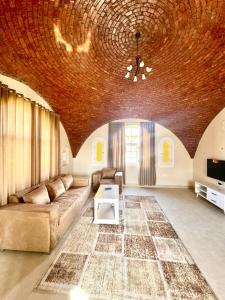 a living room with a couch and a table at Royal Home Dome Style - Top Floor Apartment in Jazīrat al ‘Awwāmīyah