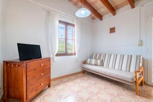 a living room with a couch and a tv on a dresser at Son Bessó in Font de Sa Cala