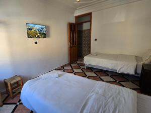 a hotel room with two beds and a tv at mouja taghazout in Taghazout