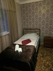 a bedroom with a bed with two towels and a window at Dachi in Itʼkhvisi