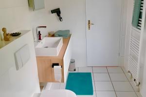 a small bathroom with a sink and a blue stool at Ferienwohnung Casa Karin mit Sauna in Bodman-Ludwigshafen
