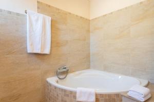 ein Bad mit einer Badewanne und Handtüchern an der Wand in der Unterkunft Caril in Binissalem + 17 Fotos