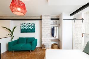 ein Wohnzimmer mit einer grünen Couch und einem Bett in der Unterkunft Galteo Almendra in Ronda
