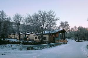 ein schneebedecktes Haus mit einem Zaun davor in der Unterkunft El Aterpe 5 in Aldehuela del Rincón