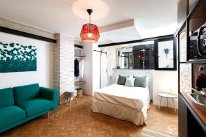 ein Schlafzimmer mit einem Bett und einer Couch in der Unterkunft Galteo Almendra in Ronda