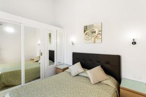 a bedroom with a bed and a mirror at Exclusive Sonemar in Maspalomas +23 photos