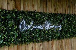 a sign on a fence with green ivy at Coolaness Glamping in Irvinestown