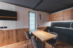 ChiesaにあるOberwiesen Rooms, Apartments & Spaの木製のテーブルと椅子のあるキッチン