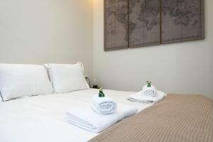 a white bed with towels on top of it at LUXURY APARTMENT JACUZZi in Málaga