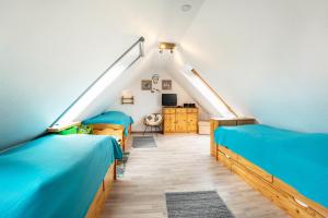 une chambre mansardée avec deux lits et une télévision dans l'établissement Ferienwohnung Wittensee, à Bünsdorf