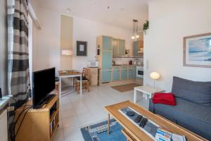 Una sala de estar con un sofá azul y una cocina. en Ferienwohnung an der Ostsee, en Sereetz