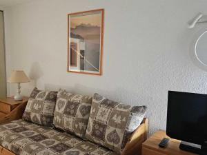 un salon avec un canapé et une télévision dans l'établissement Appart 4 pers avec WIFI, animaux admis, proche pistes - Les Menuires - FR-1-574-66, aux Menuires