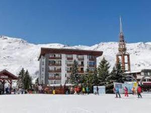 un bâtiment dans la neige en face d'une station de ski dans l'établissement Appart 4 pers avec WIFI, animaux admis, proche pistes - Les Menuires - FR-1-574-66, aux Menuires