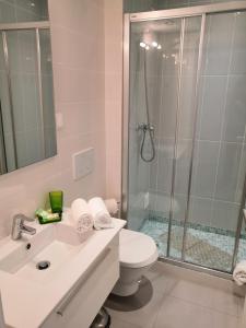a bathroom with a shower and a toilet and a sink at Bay View Albufeira in Albufeira