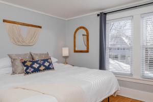 a white bedroom with a bed and a window at Bungalow on Baldwin - 3 bed 2 bath in Oshkosh +13 photos