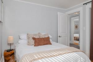 a bedroom with a bed with white sheets and pillows at Bungalow on Baldwin - 3 bed 2 bath in Oshkosh