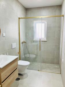 a bathroom with a shower and a toilet and a sink at Casa Elo - Fresh-Built Home with Pool in Alcorochel +11 photos