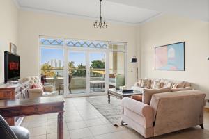 Una sala de estar con un sofá y sillas y una mesa. en VayK - Beachfront 1BR with Sea Views in Palm Jumeirah, en Dubái