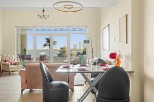 Un comedor con mesa y sillas y una sala de estar. en VayK - Beachfront 1BR with Sea Views in Palm Jumeirah, en Dubái