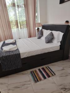 a bed with white sheets and pillows in a bedroom at Charlotte Inn in Kandy