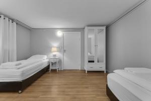 a bedroom with two beds and a table and a mirror at Castle Inn Apartments - Downtown Keflavík in Keflavík +43 photos