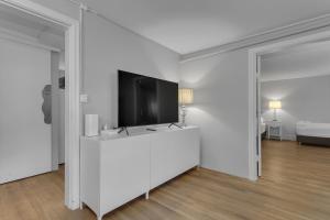 a living room with a flat screen tv on a white wall at Castle Inn Apartments - Downtown Keflavík in Keflavík
