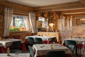 a restaurant with tables and chairs in a room at Alpen Chalet - Charme Mountain Hotel - in Schilpario