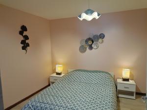 une chambre avec un lit et deux tables de nuit avec lumières dans l'établissement Sagette, à Laruns