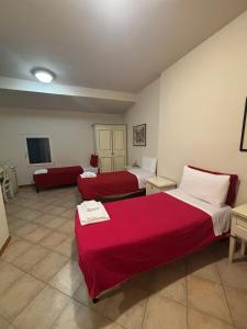 a hotel room with two beds and a red blanket at QOELET - B&B Etico e Sociale in Montevarchi