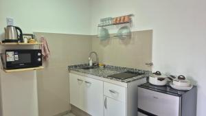 a small kitchen with a sink and a microwave at Delvi Nelly - Belgrano in Neuquén