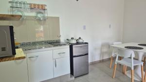 a kitchen with white cabinets and a counter top at Delvi Nelly - Belgrano in Neuquén