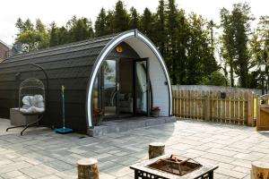 a black and white shed with a patio at Coolaness Glamping in Irvinestown