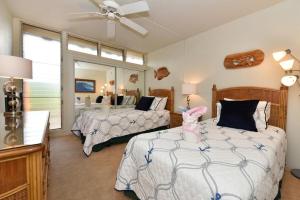 a bedroom with two beds and a large window at Kulakane 304 in Kahana +43 photos