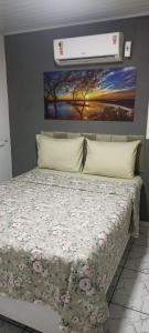 a bedroom with a bed with a floral bedspread at Casa de Jovan in Cayru