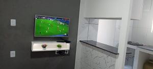 a room with a tv on a wall with flowers at Casa de Jovan in Cairu +1 photo