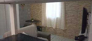 a living room with two chairs and a television at Casa de Jovan in Cairu