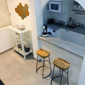 een keuken met 2 krukken en een aanrecht met een magnetron bij The Loft Malaga Center in Málaga