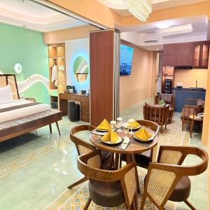 ジョグジャカルタにあるLuxury Malioboro Hotelのテーブル、椅子、ベッドが備わる客室です。