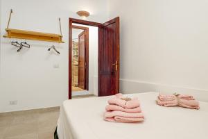 Cette chambre comprend un lit avec des serviettes roses. dans l'établissement Elia's House, à Porto Istana 18 autres photos