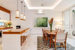 une cuisine et une salle à manger avec une table et des chaises en bois dans l'établissement Villa Vana, Sitara Villa Group, à Seminyak
