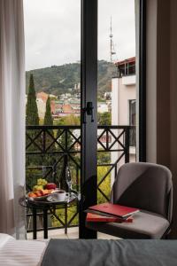 una stanza con vista su un tavolo con un piatto di frutta di White Hill Hotel a Tbilisi City