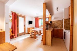 Una cocina con gabinetes de madera y una mesa en ella. en La Bévéria, en Pralognan-la-Vanoise