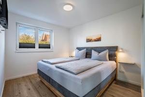 a bedroom with a large bed and a window at Ostseerauschen in Hohwacht