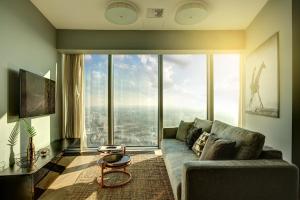 een woonkamer met een bank en een groot raam bij Sky Tower Panorama Apartments in Wrocław