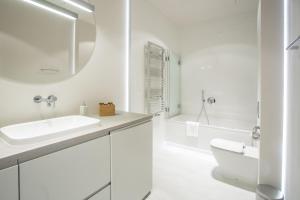 een witte badkamer met een wastafel en een toilet bij Sky Tower Panorama Apartments in Wrocław +31 foto's