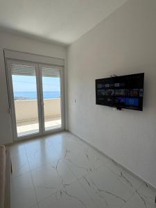 sala de estar con TV y vistas a la playa en Apartmani Kula, en Pečurice