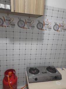 een keuken met een fornuis en een betegelde muur bij Mwembeni Abode in Bamburi +1 foto